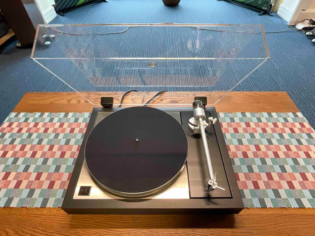 The Linn Sondek LP12 is one of the most continuously developed turntables ever made. Tracing its lineage back to the early 1970s — through the Ariston RD11 and Thorens TD150 — the LP12's suspended subchassis design has been refined over five decades into something genuinely remarkable. Our demonstration Majik LP12, finished in a smart black fluted plinth, represents the entry point into the LP12 family. Don't let the word "entry" mislead you. This is a serious turntable that outperforms many rivals at significantly higher prices. At its heart is the Karousel main bearing, introduced by Linn in March 2020. Using a Diamond Like Carbon (DLC) coating on the thrust pad, the Karousel is exceptionally smooth and low friction — lowering the noise floor and extracting more of what's in the groove. The Krane tonearm, made by respected German manufacturer Clearaudio, replaces earlier Linn designs. It delivers an even, consistent performance across the frequency range with a full, engaging midband. It works well with both moving magnet and moving coil cartridges up to £1,000, and responds well to a better tonearm cable — Linn's own T cable being an excellent choice. Available with a choice of cartridges: the Adikt moving magnet at £3,700 or the Audio Technica derived Koil moving coil at £3,935. The power supply runs at 33⅓ RPM as standard. For those wanting 45 RPM capability or improved speed stability, popular options include the Mose Hercules and Valhalla Minos supplies, or Linn's own Lingo 4 for those who prefer to stay within the Linn ecosystem. The cumulative effect of Linn's ongoing development programme is evident throughout — every fastening, the plinth design, the top plate — all continuously improved. The result is a turntable that works brilliantly as a one-stop solution or as the starting point for a structured upgrade path. Call Andrew to arrange a demonstration in our Gateshead showroom or in your own home.